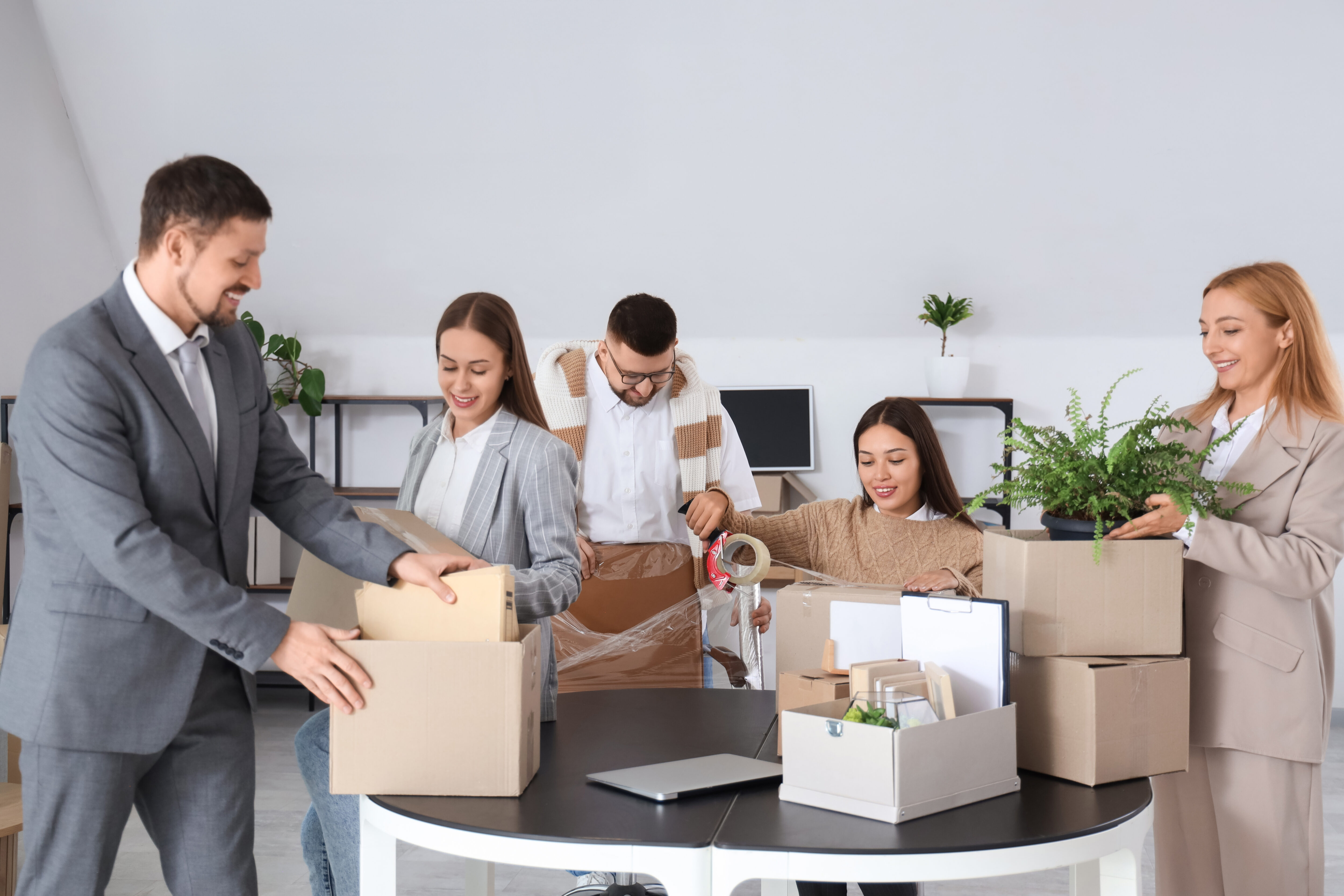 Group of business people packing things in office on moving day