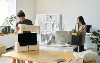 Young business people packing things during the move in other office